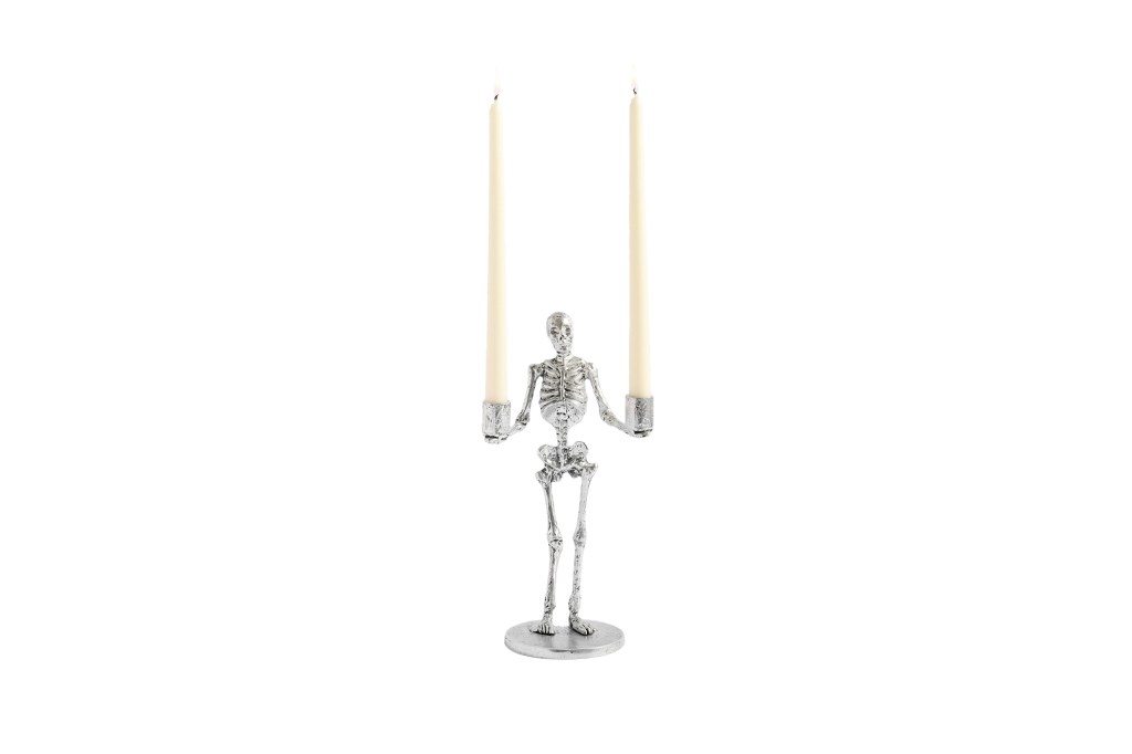 A skeleton holding two candles